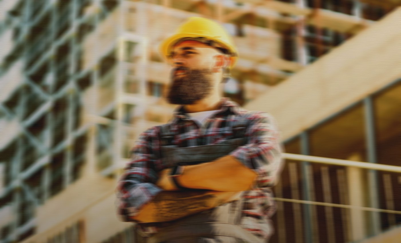 Roofer in a hard hat on a framed job site